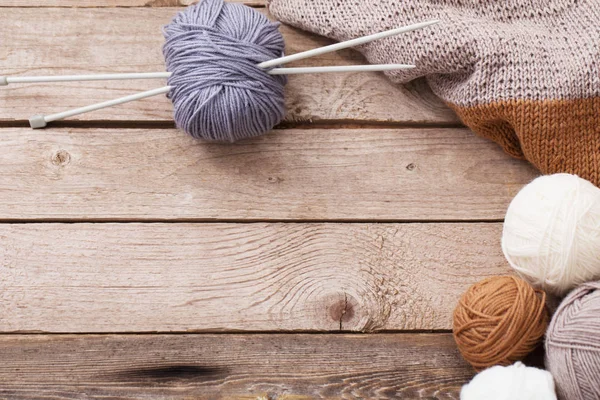 Knitting and knitting needles on a wooden surface