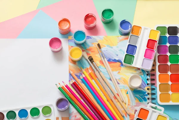Краски, карандаши и кисти на бумаге — стоковое фото