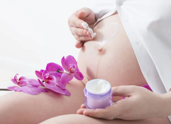 Mujer embarazada con crema cosmética — Foto de Stock