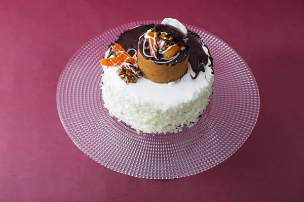 Торт на скляній тарілці на червоному тлі — стокове фото