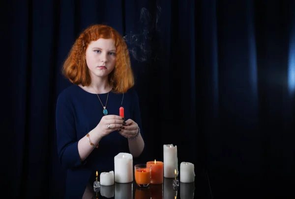 Giovane ragazza con candele su sfondo blu scuro — Foto Stock