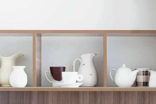 White kitchenware on wooden shelf — Stock Photo, Image