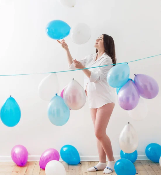 Schwangere mit Luftballons drinnen — Stockfoto