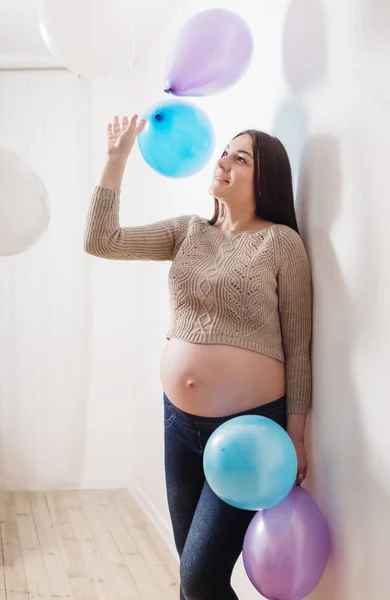 Gelukkig zwangeren met ballonnen binnen — Stockfoto
