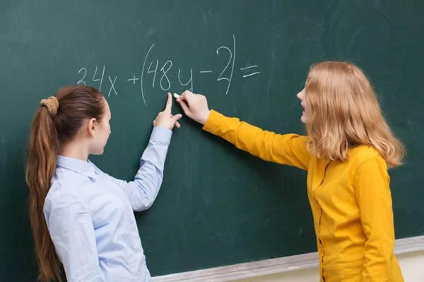Deux filles au tableau noir dans un cours de mathématiques — Photo