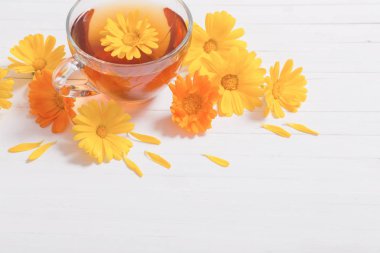 Beyaz ahşap masa Calendula (kadife çiçeği) bitkisel çay