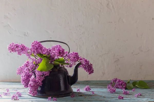 Сирень цветы в металлическом чайнике на белом старом фоне — стоковое фото