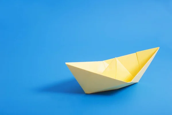 Barco de papel sobre fondo de papel azul — Foto de Stock