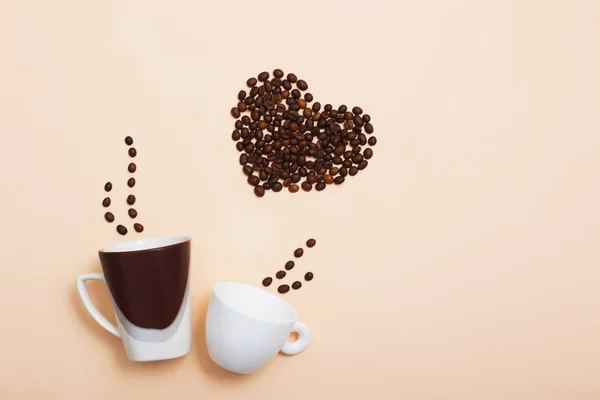 Deux tasses avec des grains de café en forme de coeur — Photo