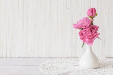 ahşap arka plan üzerinde beyaz vazoda pembe Şakayık