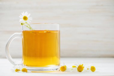 Beyaz ahşap zemin üzerinde papatya çayı