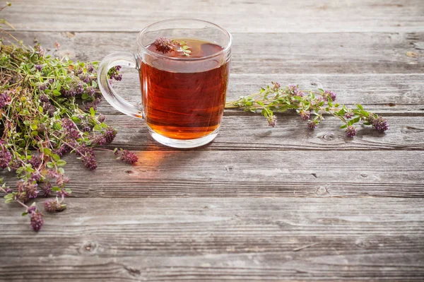 Чай с тимьяном на старом деревянном фоне — стоковое фото