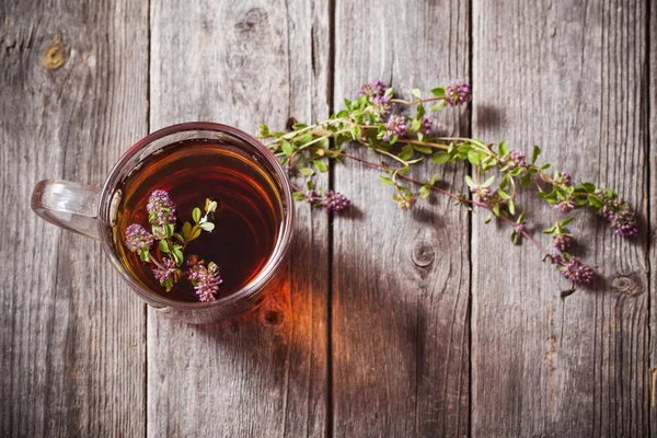Tea with thyme on old wooden background — Stock Photo, Image