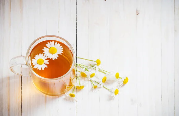 Чай с ромашкой на белом деревянном фоне — стоковое фото