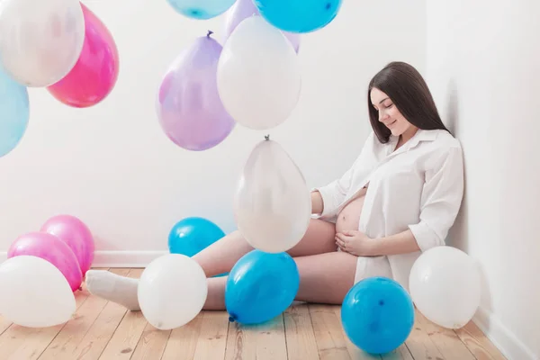 Schwangere mit Luftballons drinnen — Stockfoto