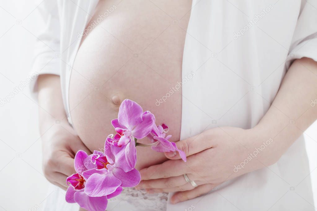 pregnant women with orchids on white background