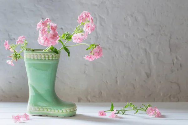 Flores de verão em bota de cerâmica no fundo branco — Fotografia de Stock