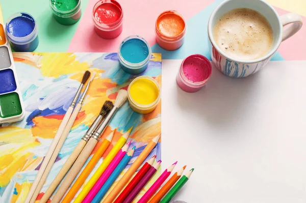 Чашка кофе и краски, карандаши на белом фоне — стоковое фото