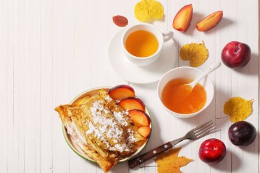 çay ve Erik beyaz tahta masada krep