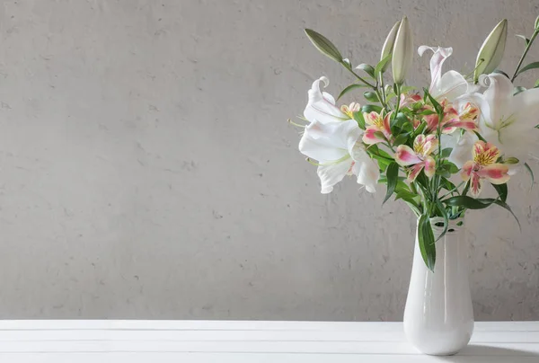 Bellissimo giglio bianco in vaso su sfondo vecchio muro — Foto Stock