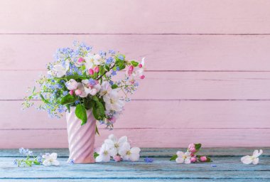 Tahta arka planda vazoda bahar çiçekleri