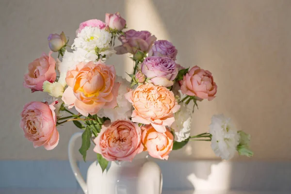 Beautiful roses in ceramic white jug — Stock Photo, Image
