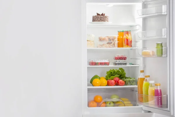 Frigorífico branco com alimentos diferentes — Fotografia de Stock