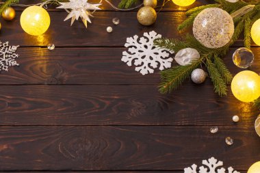 Karanlık ahşap arka planda ışıkları olan Noel süslemeleri.