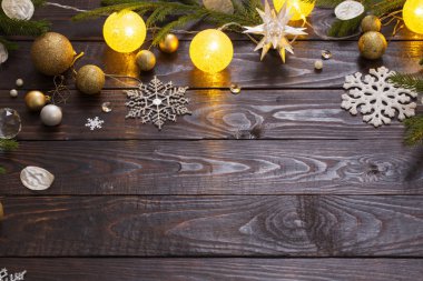 Karanlık ahşap arka planda ışıkları olan Noel süslemeleri.