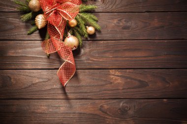 Koyu ahşap arka planda altın ve kırmızı Noel süslemeleri 