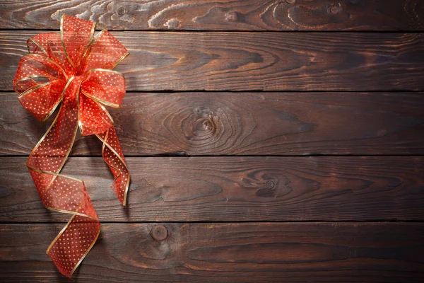 Rood en gouden strik op donkere houten achtergrond — Stockfoto