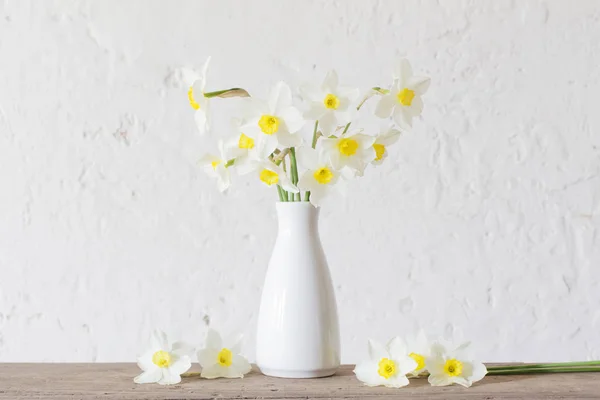 Narcisos en jarrón blanco sobre fondo blanco — Foto de Stock