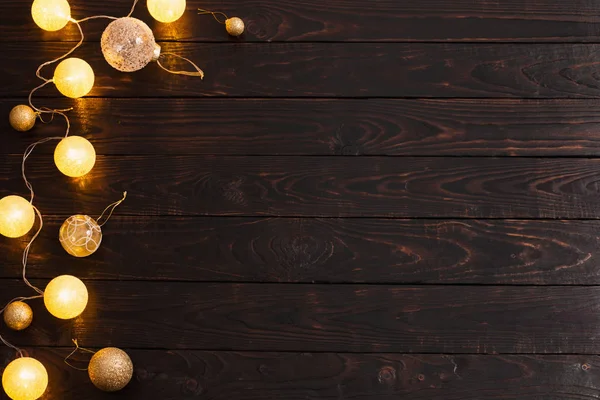 Lumières dorées de Noël sur fond bois foncé — Photo