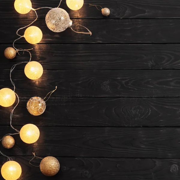 Christmas golden lights on dark wooden background — Stock Photo, Image