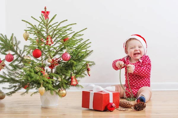 Rolig bebis med liten julgran hemma — Stockfoto