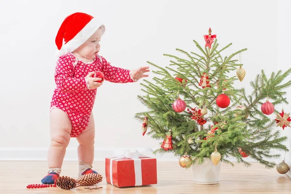 Funny baby with little Christmas fir at home — ストック写真