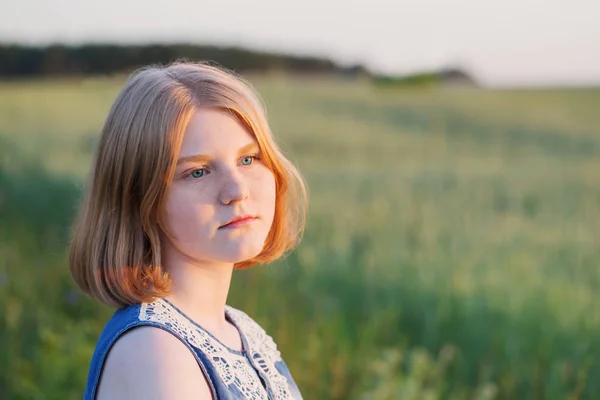 Teenager girl in summer field at sunset — Stock Photo, Image
