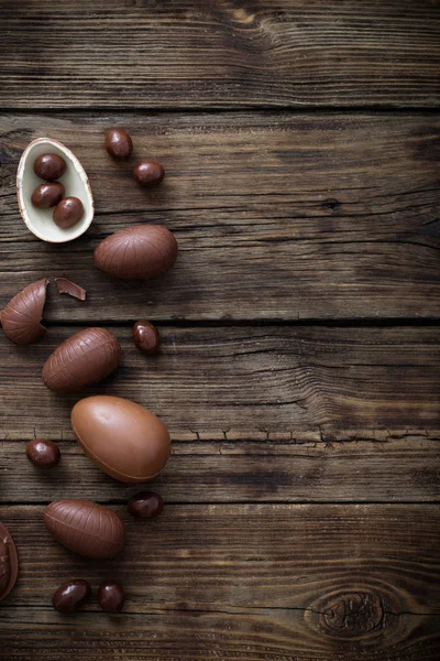 Oeufs en chocolat sur fond de bois foncé — Photo