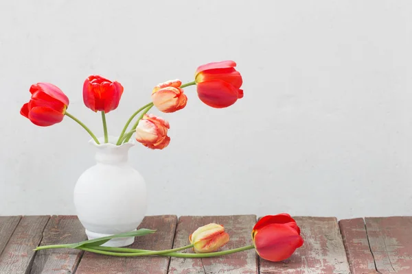 Tulipas em vaso no fundo velho branco — Fotografia de Stock