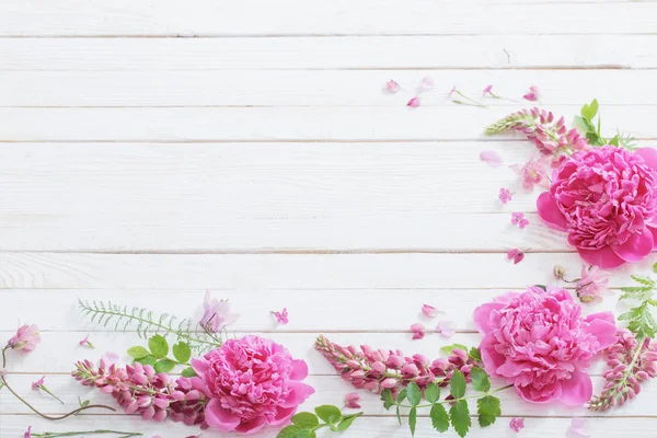 Rosa schöne Blumen auf weißem Holzhintergrund — Stockfoto