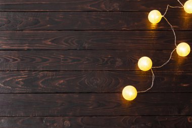 Koyu ahşap arka planda Noel altın ışıkları