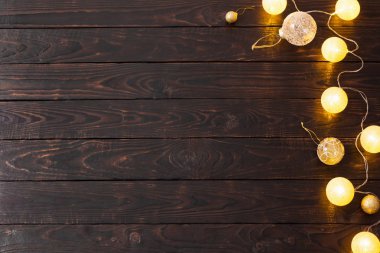 Koyu ahşap arka planda Noel altın ışıkları