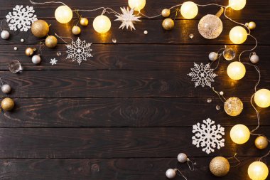 Karanlık ahşap arka planda ışıkları olan Noel süslemeleri.