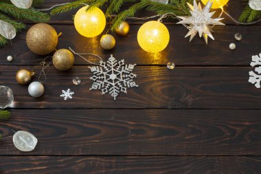 Karanlık ahşap arka planda ışıkları olan Noel süslemeleri.