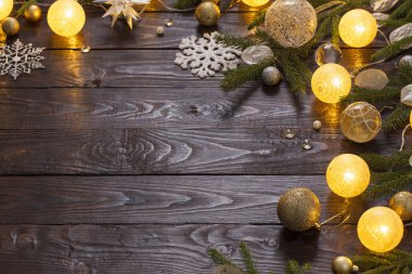Karanlık ahşap arka planda ışıkları olan Noel süslemeleri.
