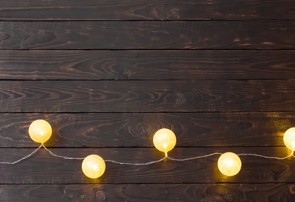 Lumières dorées de Noël sur fond bois foncé — Photo