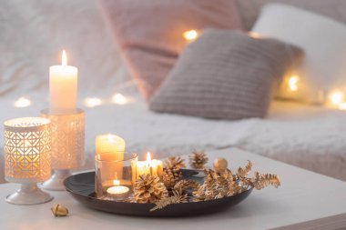 Beyaz masa üzerinde yanan mumlarla Noel süslemesi