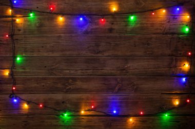 Tahta bir sörf tahtasında çok renkli ampulleri olan elektrik çelengi.