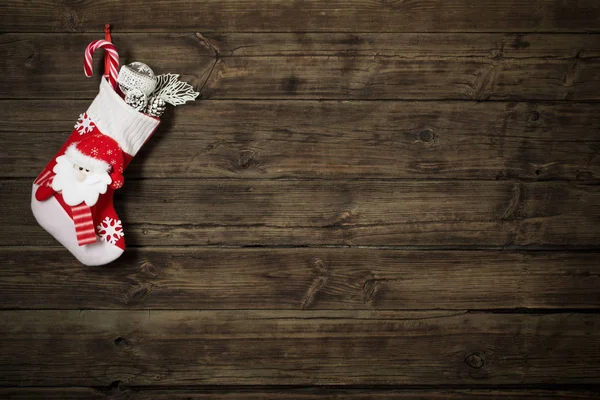 Christmas stocking with gifts hanging on dark old wooden backgro — Stock Photo, Image