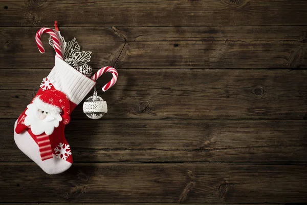 Meia de Natal com presentes pendurados no escuro velho backgro de madeira — Fotografia de Stock